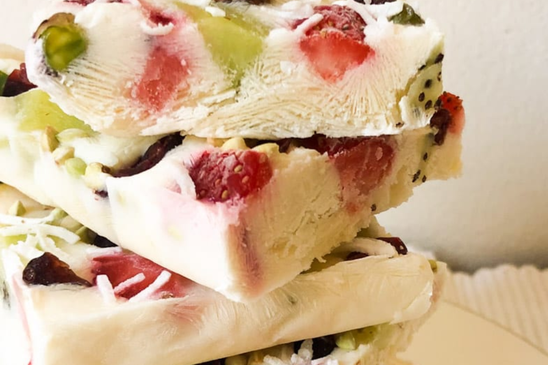 Festive yoghurt bark slices stacked in a pile.